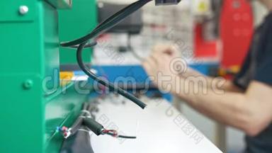 工作服前电工的机械设备电线与能源面板和机械设备一起工作